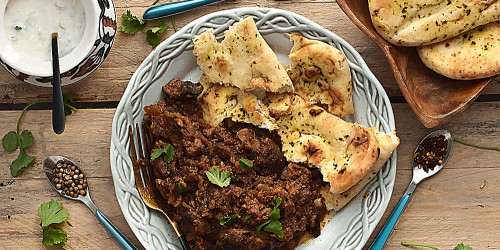 Homemade Lamb bhuna curry with naan bread and raita