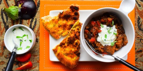 Vegetarian tomato and aubergine bhuna curry served with naan bread and cucumber raita