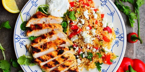 Greek lemon & oregano chicken with a rice salad with red pepper, feta flavoured with chilli and lemon and served with Tzatziki