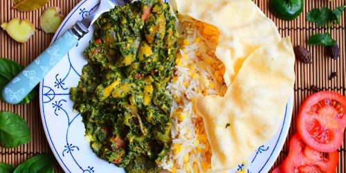 Indian vegetarian mushroom and spinach curry served with lentil rice and popadoms