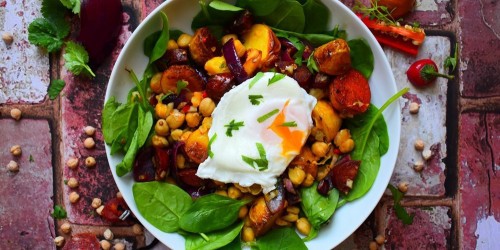 Chorizo and potato salad with chickpeas served on a bed of spinach topped with a poached egg
